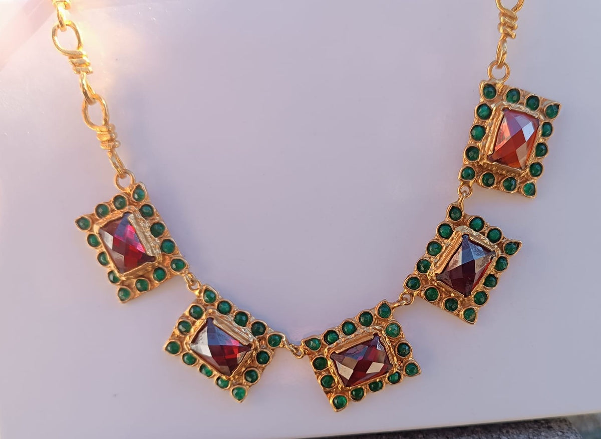 Spettacolare collana girocollo artigianale in bronzo oro opaco con elementi geometrici incastonati di giade verdi e quarzi rosso arancio sfaccettati.
