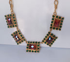 Spettacolare collana girocollo artigianale in bronzo oro opaco con elementi geometrici incastonati di giade verdi e quarzi rosso arancio sfaccettati.