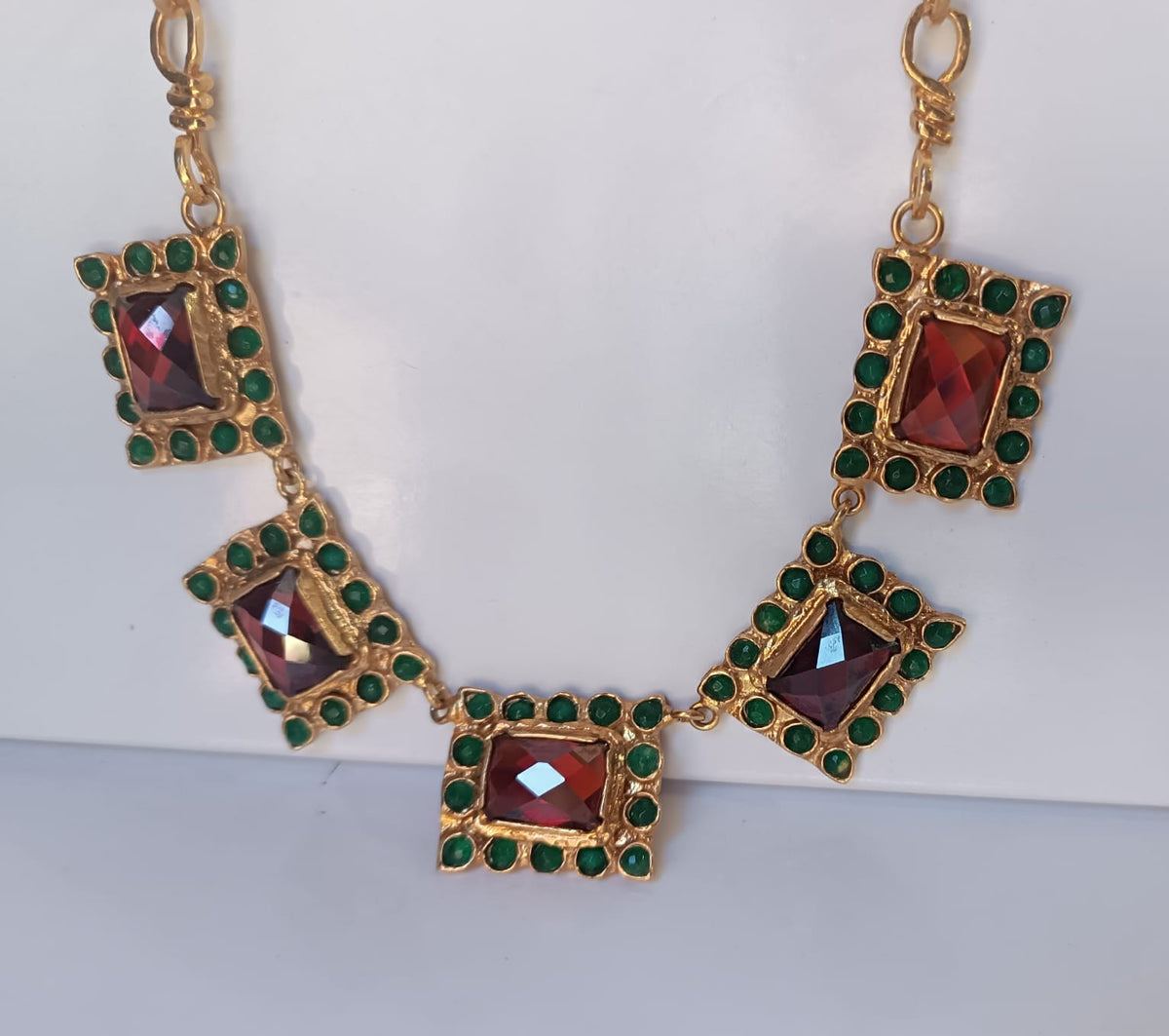 Spettacolare collana girocollo artigianale in bronzo oro opaco con elementi geometrici incastonati di giade verdi e quarzi rosso arancio sfaccettati.