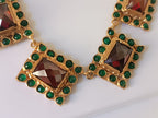 Spettacolare collana girocollo artigianale in bronzo oro opaco con elementi geometrici incastonati di giade verdi e quarzi rosso arancio sfaccettati.
