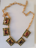 Spettacolare collana girocollo artigianale in bronzo oro opaco con elementi geometrici incastonati di giade verdi e quarzi rosso arancio sfaccettati.