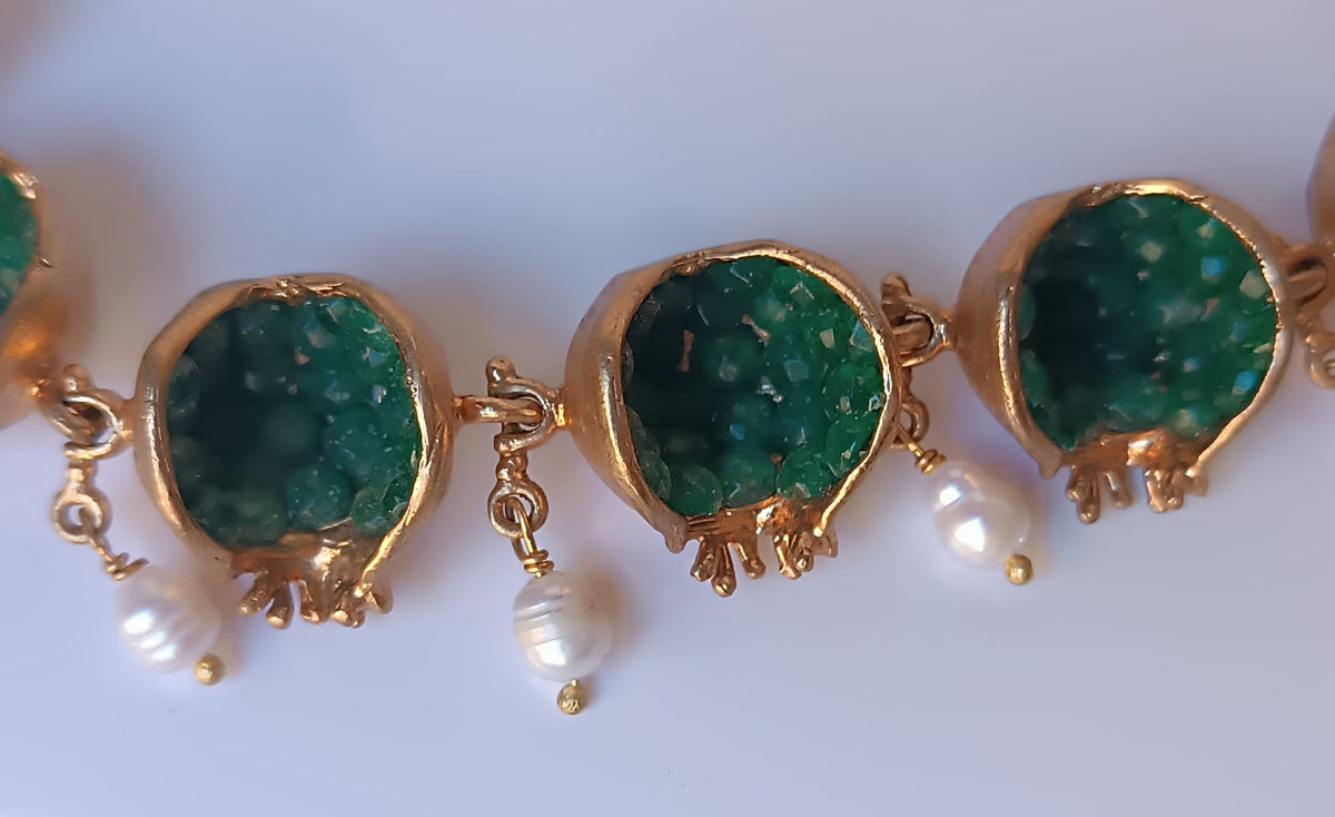 Spettacolare collana artigianale in bronzo oro opaco con melagrane scolpite aperte contenenti giade verdi naturali e perle pendenti.