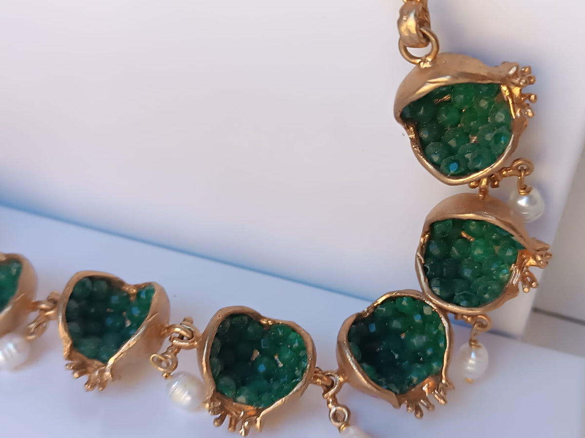 Spettacolare collana artigianale in bronzo oro opaco con melagrane scolpite aperte contenenti giade verdi naturali e perle pendenti.