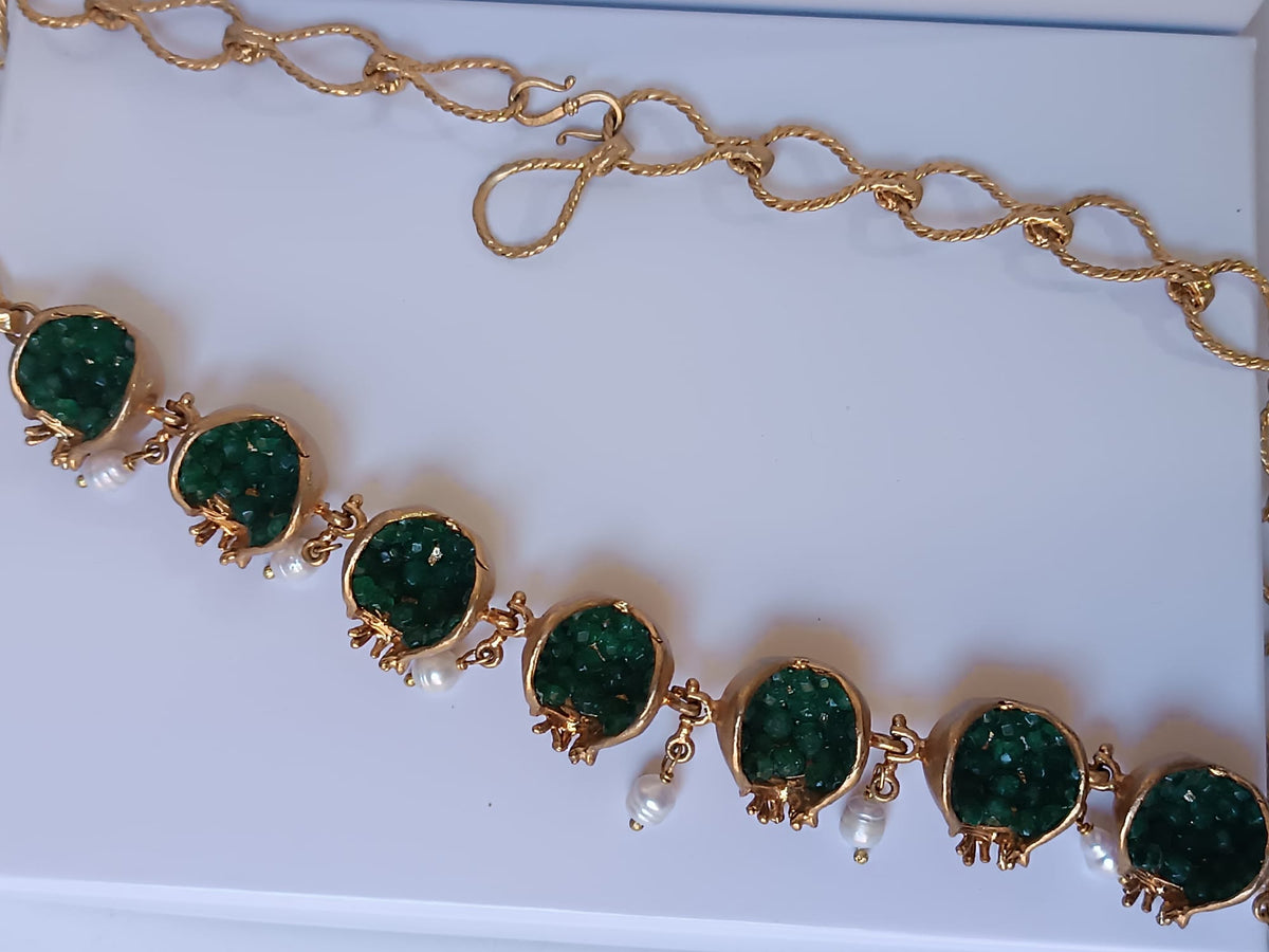 Spettacolare collana artigianale in bronzo oro opaco con melagrane scolpite aperte contenenti giade verdi naturali e perle pendenti.