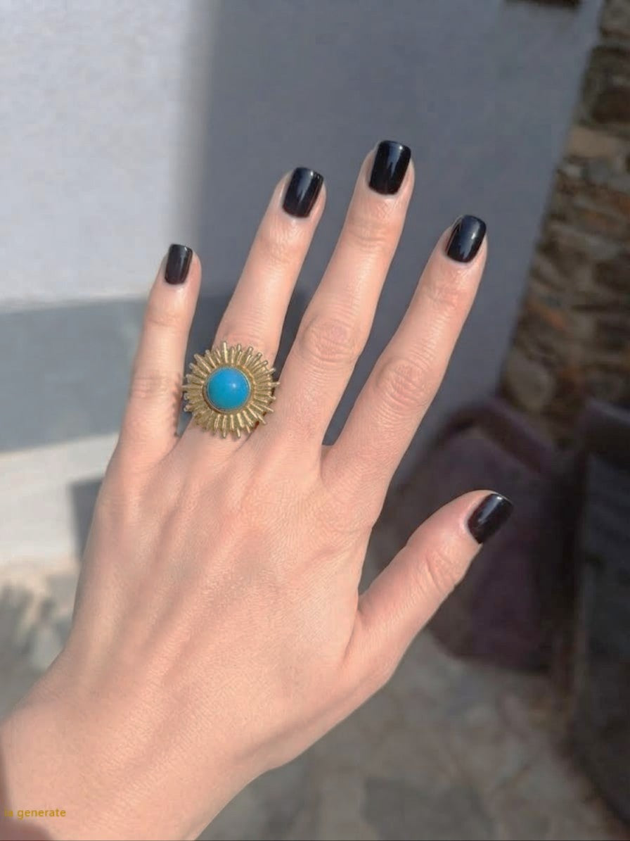 Anello scultoreo a raggiera solare in bronzo dorato con pietra tonda di quarzite azzurra centrale