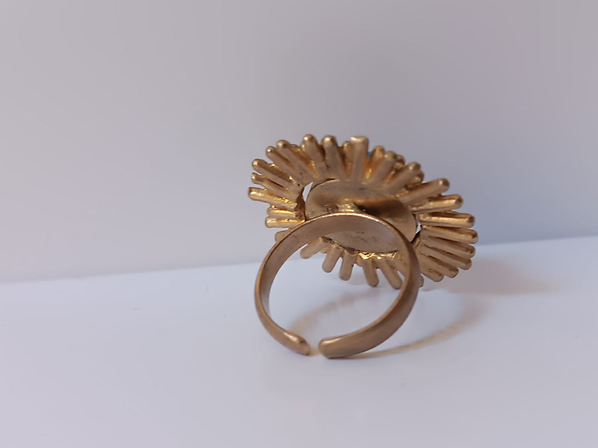 Anello scultoreo a raggiera solare in bronzo dorato con pietra tonda di quarzite azzurra centrale
