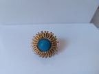 Anello scultoreo a raggiera solare in bronzo dorato con pietra tonda di quarzite azzurra centrale