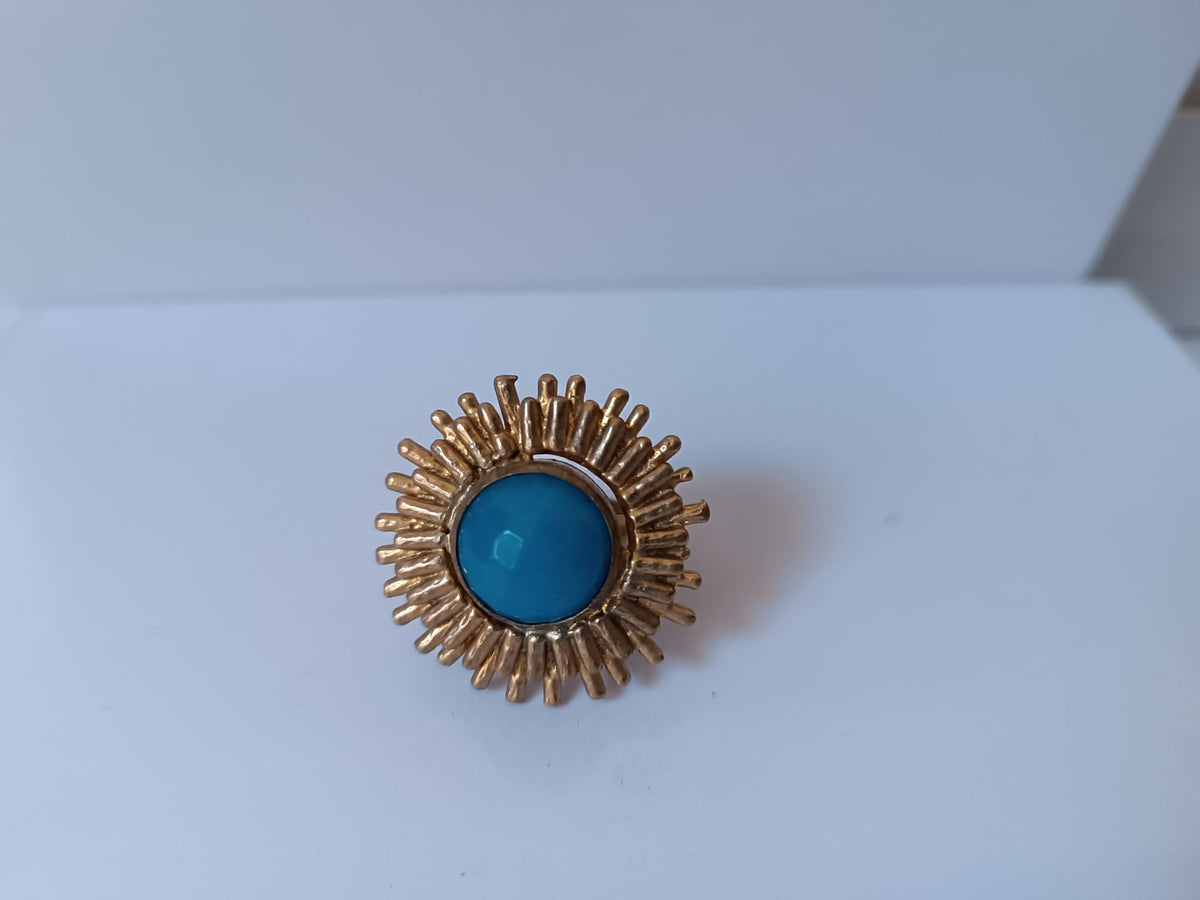 Anello scultoreo a raggiera solare in bronzo dorato con pietra tonda di quarzite azzurra centrale