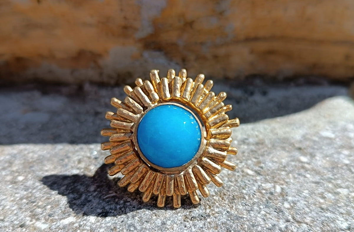 Anello scultoreo a raggiera solare in bronzo dorato con pietra tonda di quarzite azzurra centrale