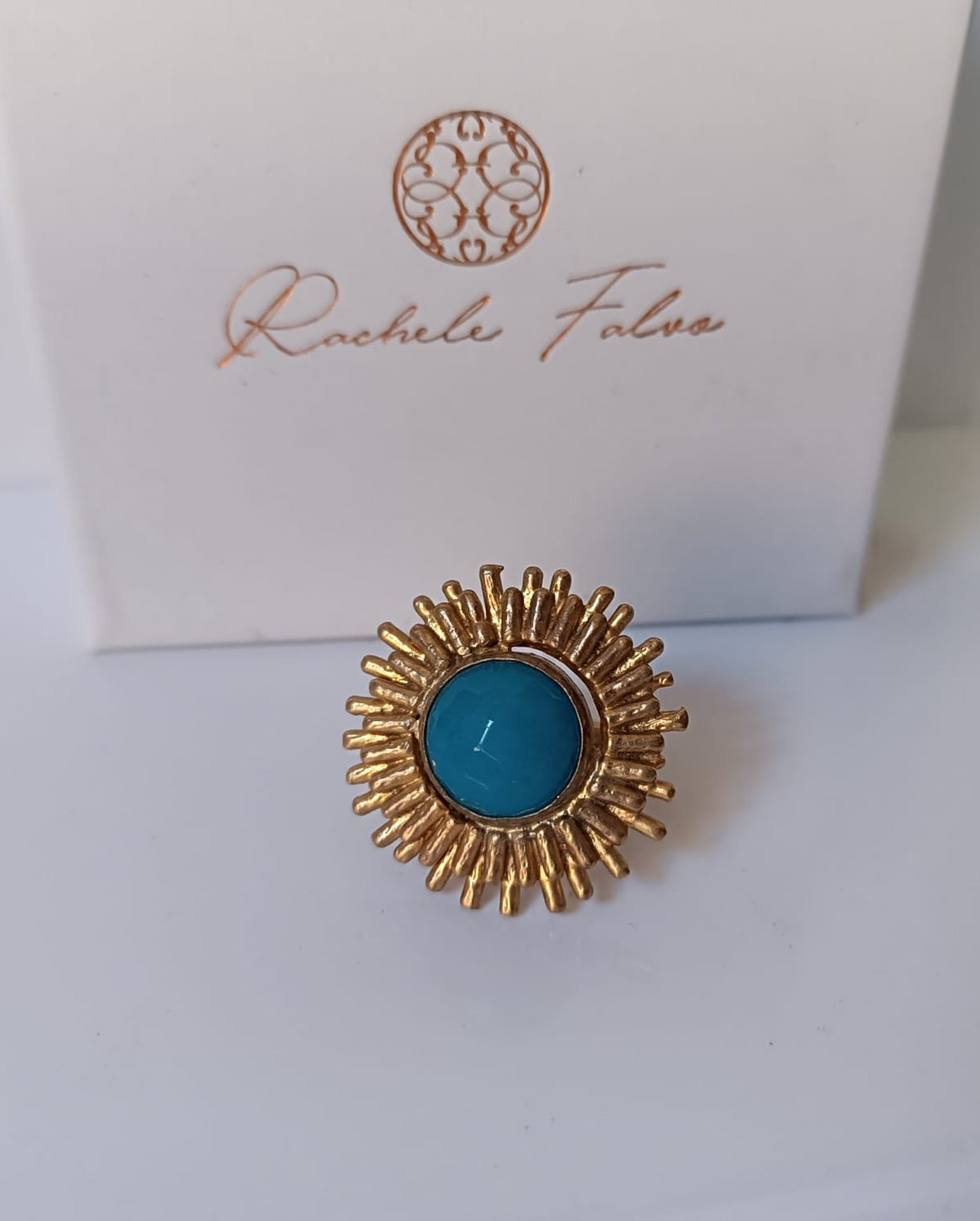 Anello scultoreo a raggiera solare in bronzo dorato con pietra tonda di quarzite azzurra centrale