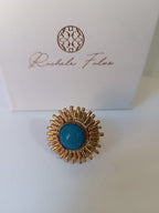 Anello scultoreo a raggiera solare in bronzo dorato con pietra tonda di quarzite azzurra centrale