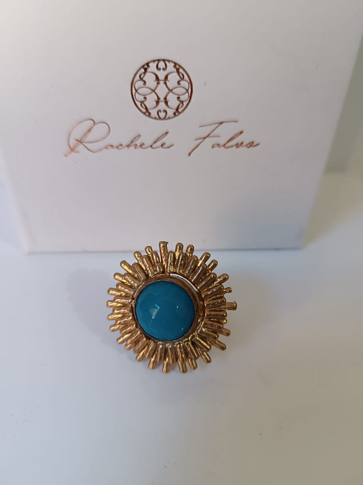 Anello scultoreo a raggiera solare in bronzo dorato con pietra tonda di quarzite azzurra centrale