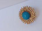 Anello scultoreo a raggiera solare in bronzo dorato con pietra tonda di quarzite azzurra centrale