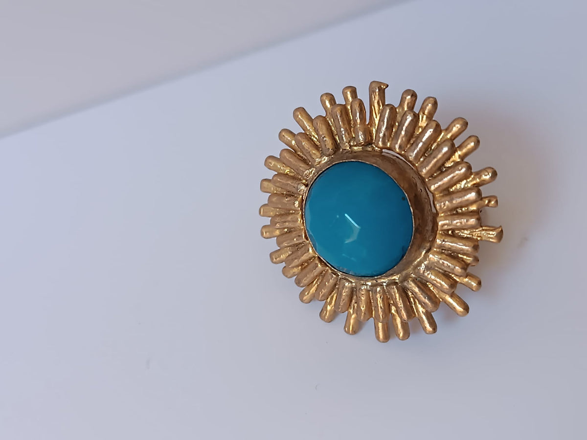 Anello scultoreo a raggiera solare in bronzo dorato con pietra tonda di quarzite azzurra centrale