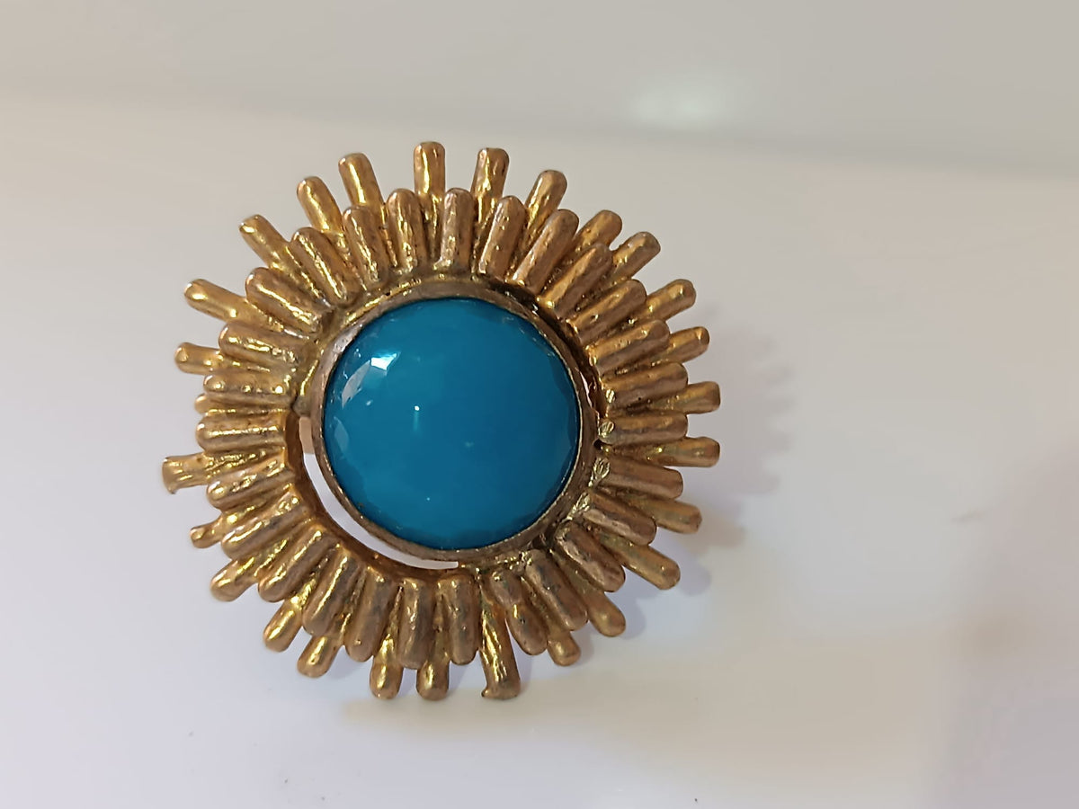 Anello scultoreo a raggiera solare in bronzo dorato con pietra tonda di quarzite azzurra centrale