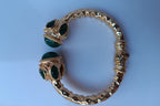 Spettacolare bracciale rigido aperto con fusto largo 1 cm in stile etrusco in bronzo dorato con terminali in giada verde