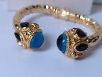 Spettacolare bracciale rigido a molla scultoreo in stile etrusco bizantino in bronzo oro opaco con azzurriti naturali sfaccettate