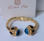 Spettacolare bracciale rigido a molla scultoreo in stile etrusco bizantino in bronzo oro opaco con azzurriti naturali sfaccettate