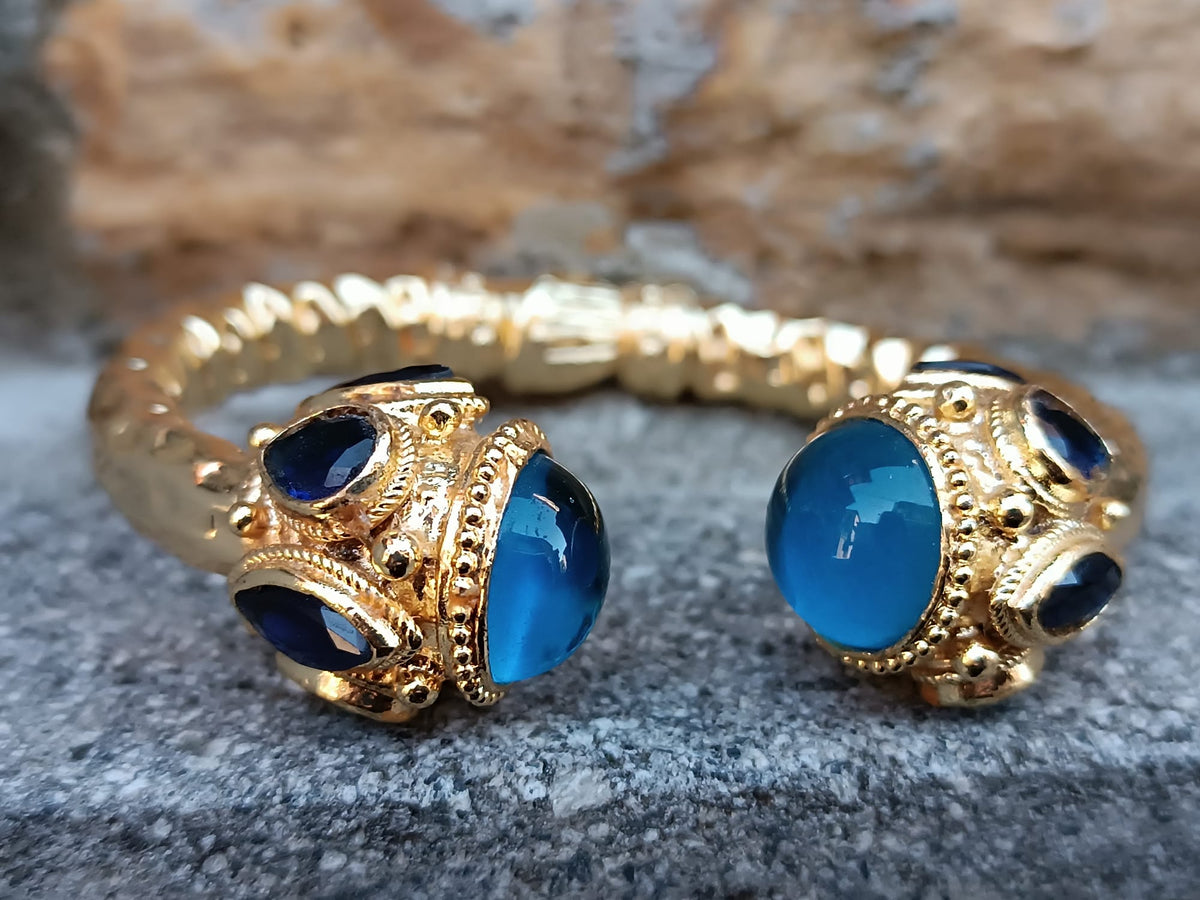 Spettacolare bracciale rigido a molla scultoreo in stile etrusco bizantino in bronzo oro opaco con azzurriti naturali sfaccettate