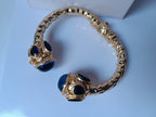 Spettacolare bracciale rigido a molla scultoreo in stile etrusco bizantino in bronzo oro opaco con azzurriti naturali sfaccettate
