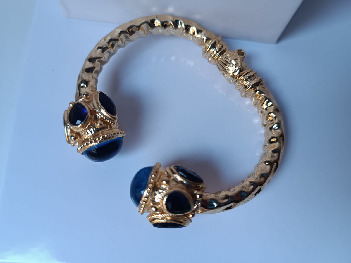 Spettacolare bracciale rigido a molla scultoreo in stile etrusco bizantino in bronzo oro opaco con azzurriti naturali sfaccettate