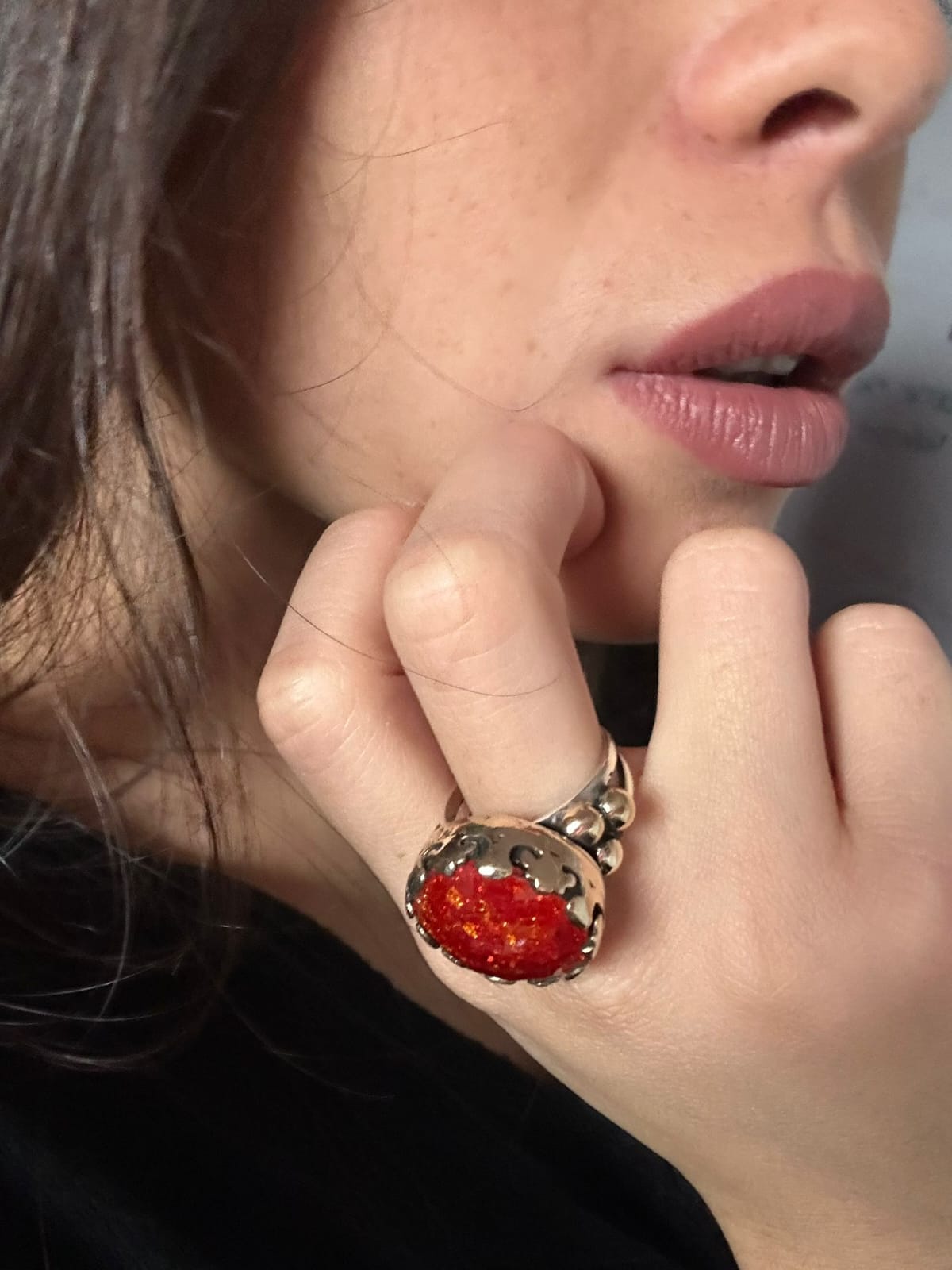 Anello artigianale in argento con avventurina stellata rossa sfaccettata, luminoso e dal design avvolgente