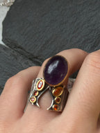 Anello in argento con ricami in oro, ametista viola cabochon e mini topazi arancio