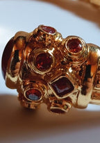 bracciale rigido in bronzo dorato a molla di Rachele Falvo in stile etrusco bizantino con intarsi e grandi diaspri rossi naturali