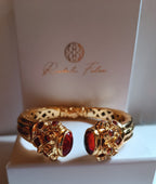 bracciale rigido in bronzo dorato a molla di Rachele Falvo in stile etrusco bizantino con intarsi e grandi diaspri rossi naturali