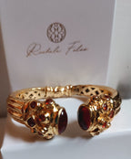 bracciale rigido in bronzo dorato a molla di Rachele Falvo in stile etrusco bizantino con intarsi e grandi diaspri rossi naturali