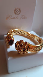 bracciale rigido in bronzo dorato a molla di Rachele Falvo in stile etrusco bizantino con intarsi e grandi diaspri rossi naturali