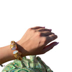 Bracciale rigido in bronzo dorato con opaline bianche sfaccettate e piccoli peridoti verdi, artigianale
