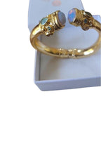 Bracciale rigido in bronzo dorato con opaline bianche sfaccettate e piccoli peridoti verdi, artigianale.