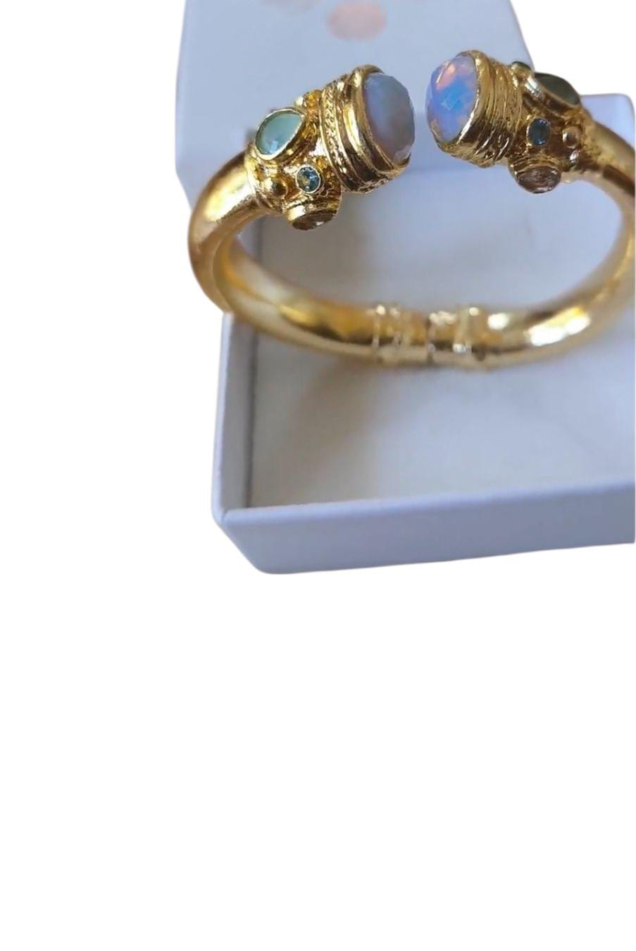 Bracciale rigido in bronzo dorato con opaline bianche sfaccettate e piccoli peridoti verdi, artigianale.