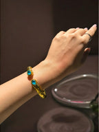 Bracciale etrusco a molla in bronzo con oro opaco e topazi azzurri naturali