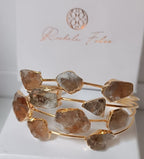 Bracciale rigido multifilo dorato firmato Rachele Falvo, impreziosito da luminose druse di quarzo bianco naturale