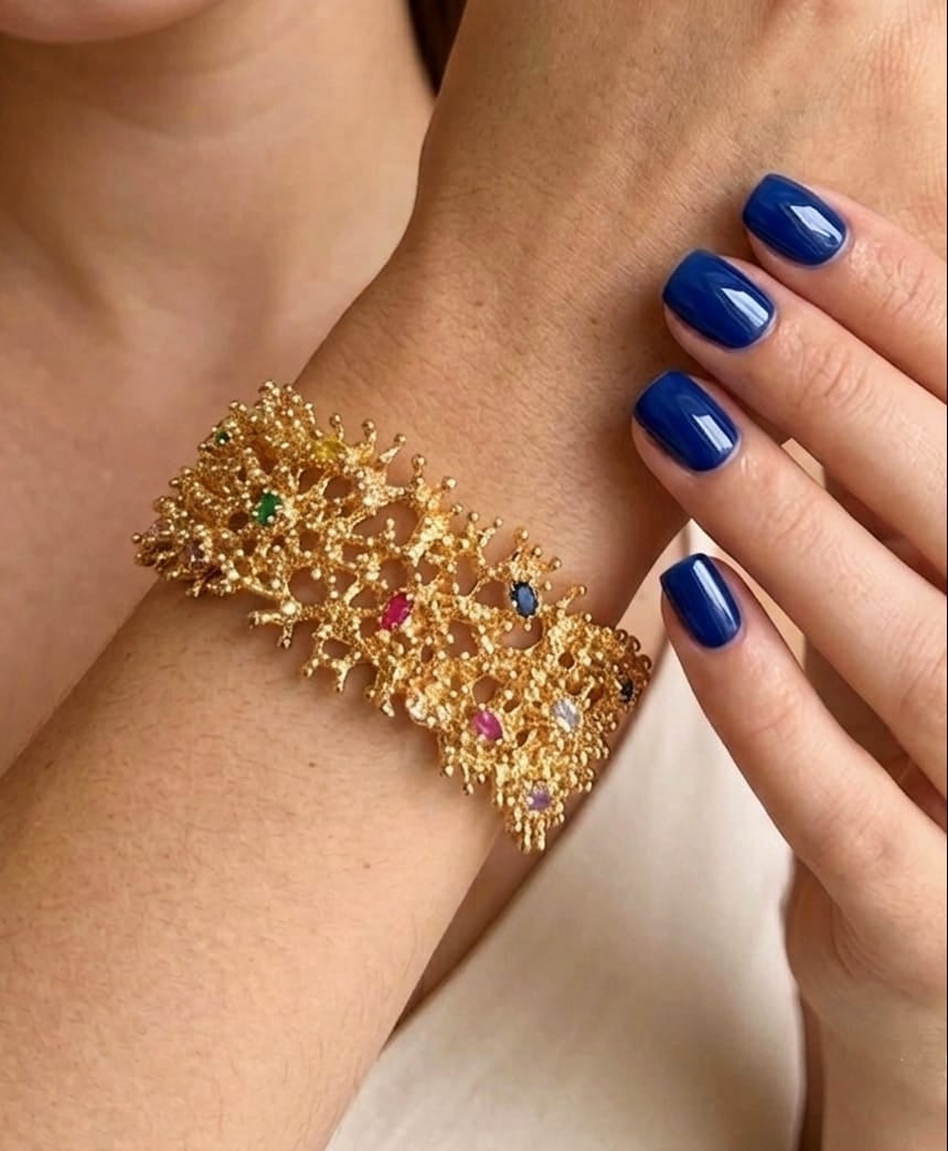 bracciale rigido di Rachele Falvo a fascia effetto corallo in bronzo dorato con incastonati topazi azzurri e quarziti multicolor naturali,