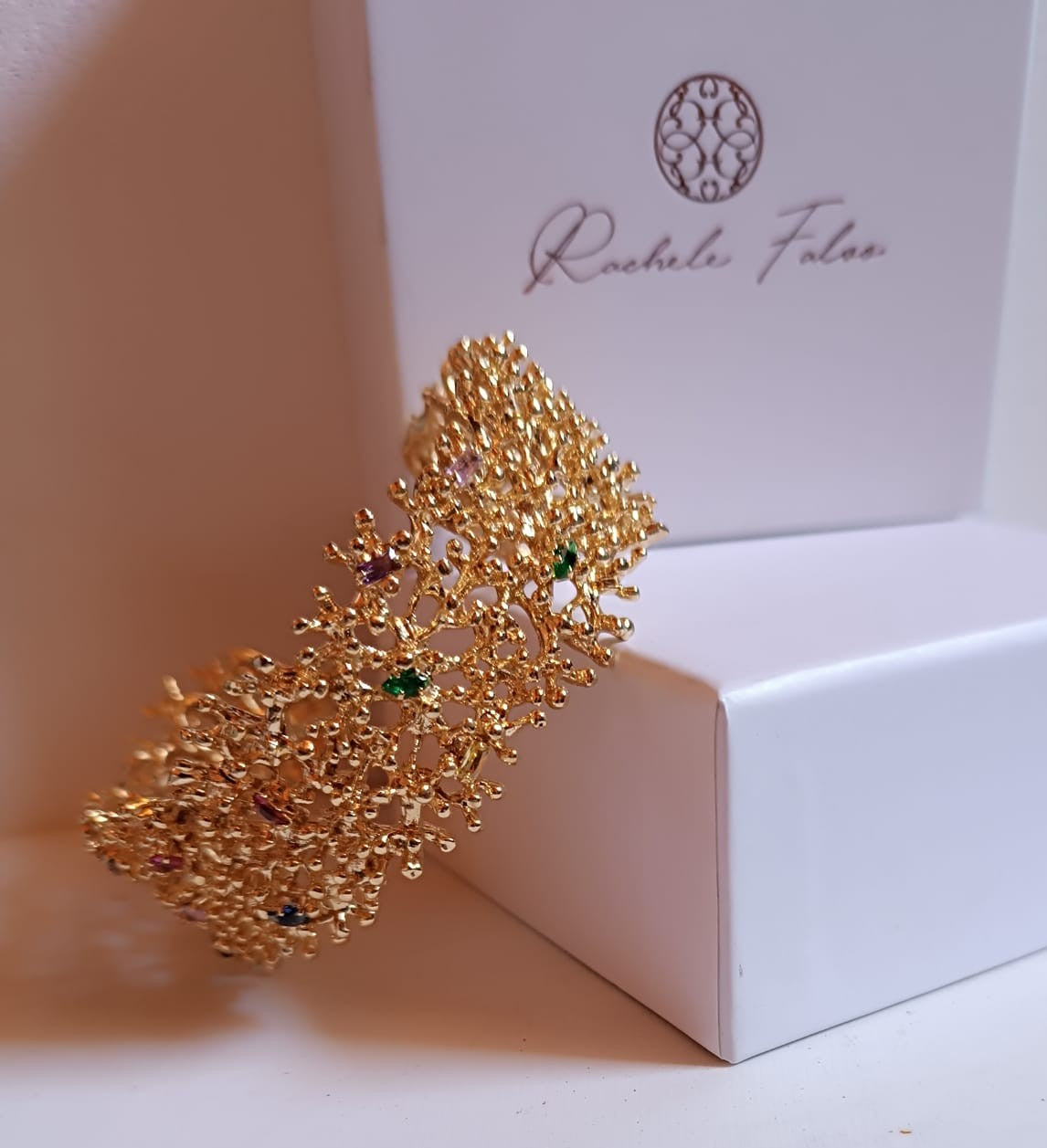 bracciale rigido di Rachele Falvo a fascia effetto corallo in bronzo dorato con incastonati topazi azzurri e quarziti multicolor naturali,
