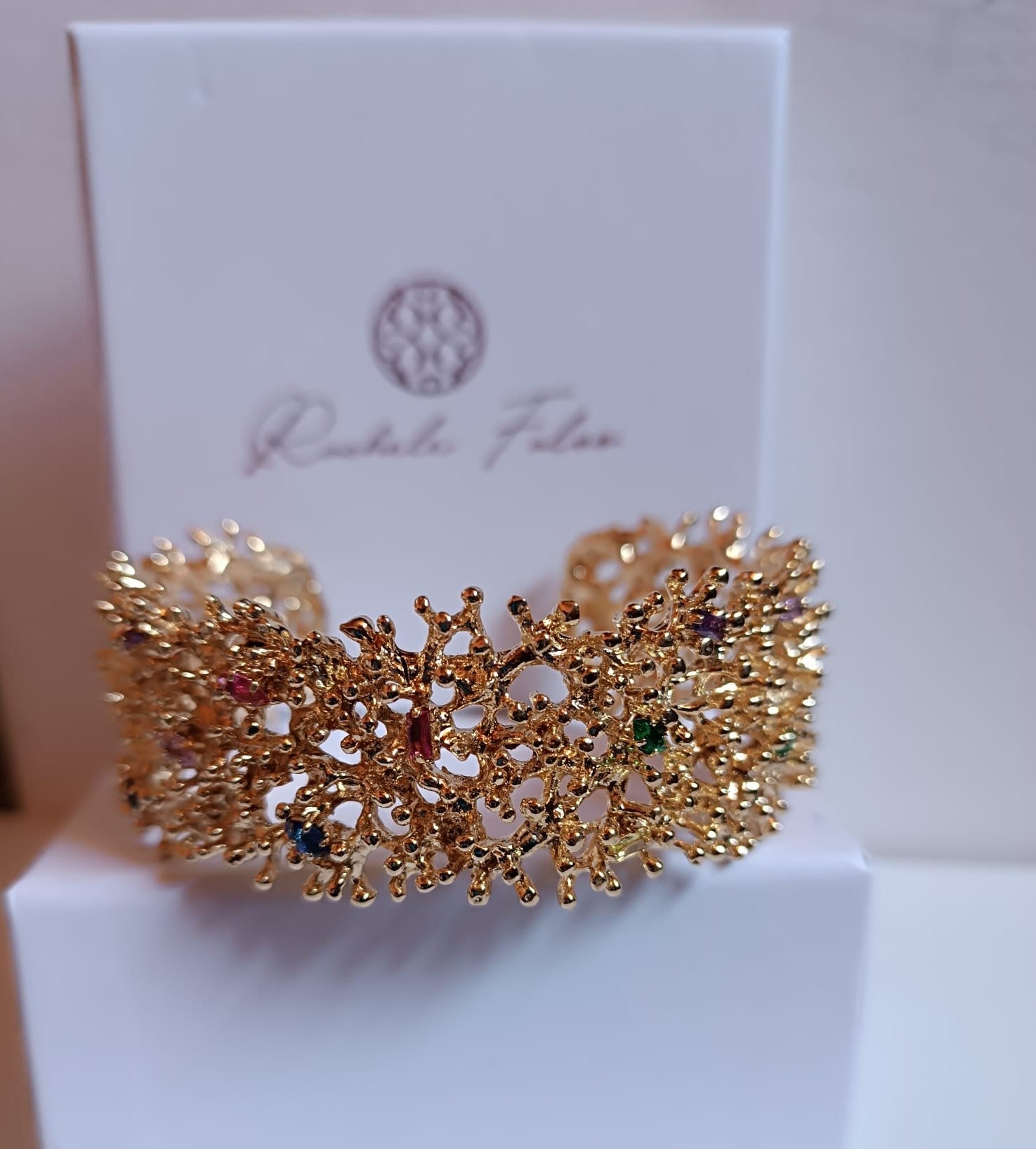 bracciale rigido di Rachele Falvo a fascia effetto corallo in bronzo dorato con incastonati topazi azzurri e quarziti multicolor naturali,