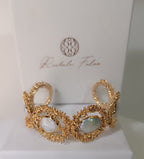  bracciale rigido dorato di Rachele Falvo con texture scultorea e due gemme ovali di madreperla bianca naturale