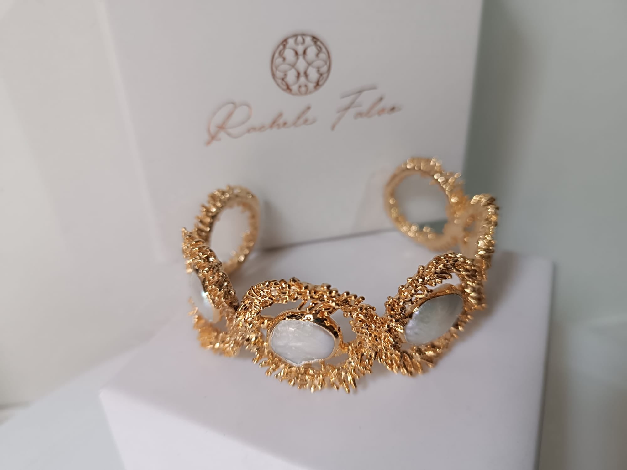  bracciale rigido dorato di Rachele Falvo con texture scultorea e due gemme ovali di madreperla bianca naturale