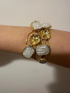 Bracciale rigido multifilo regolabile firmato Rachele Falvo in bronzo dorato, decorato con fiori scultorei in rilievo e grandi placche geometriche di madreperla naturale lucida
