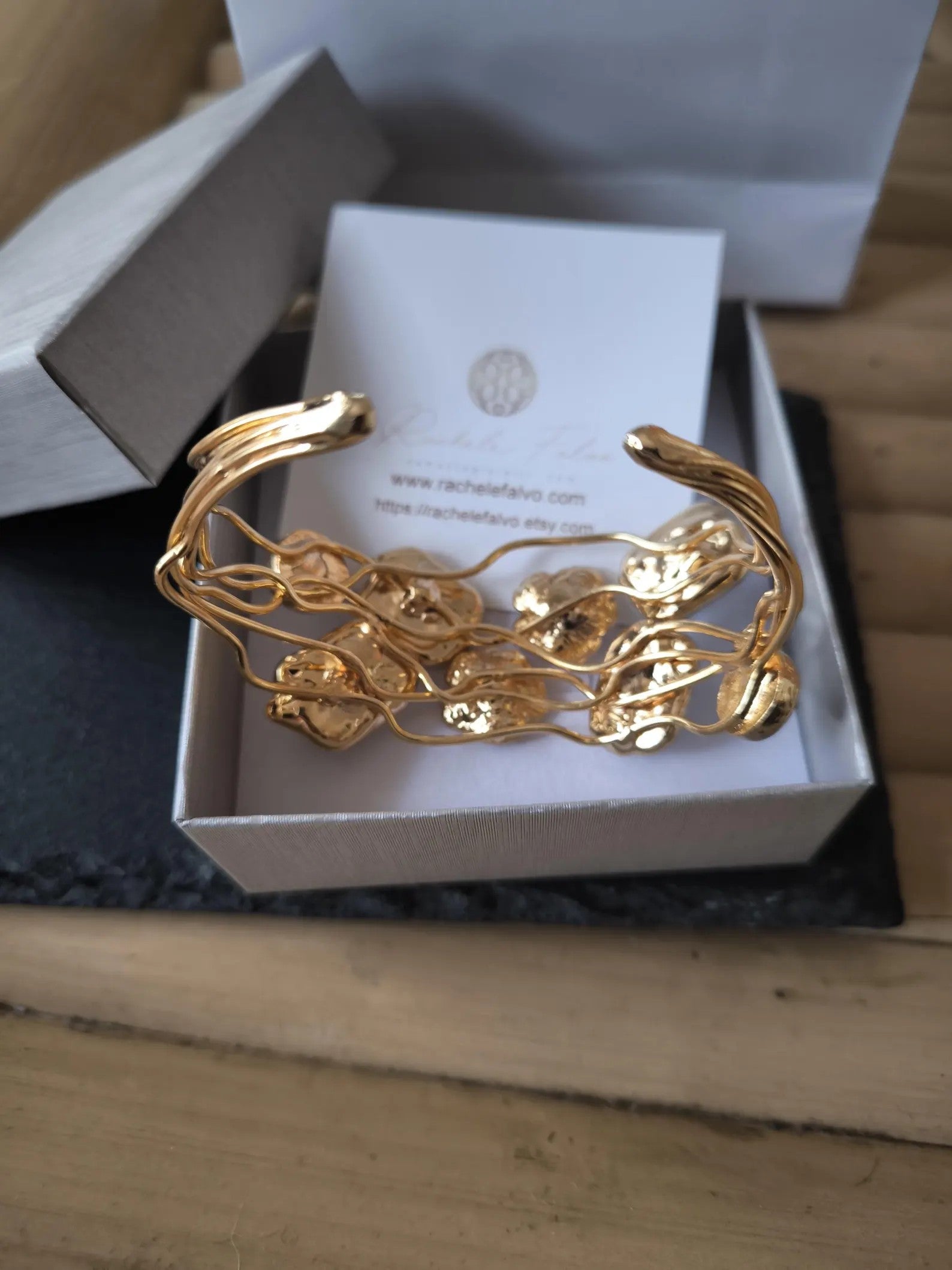 Bracciale rigido multifilo regolabile firmato Rachele Falvo in bronzo dorato, decorato con fiori scultorei in rilievo e grandi placche geometriche di madreperla naturale lucida