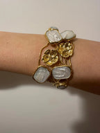 Bracciale rigido multifilo regolabile firmato Rachele Falvo in bronzo dorato, decorato con fiori scultorei in rilievo e grandi placche geometriche di madreperla naturale lucida
