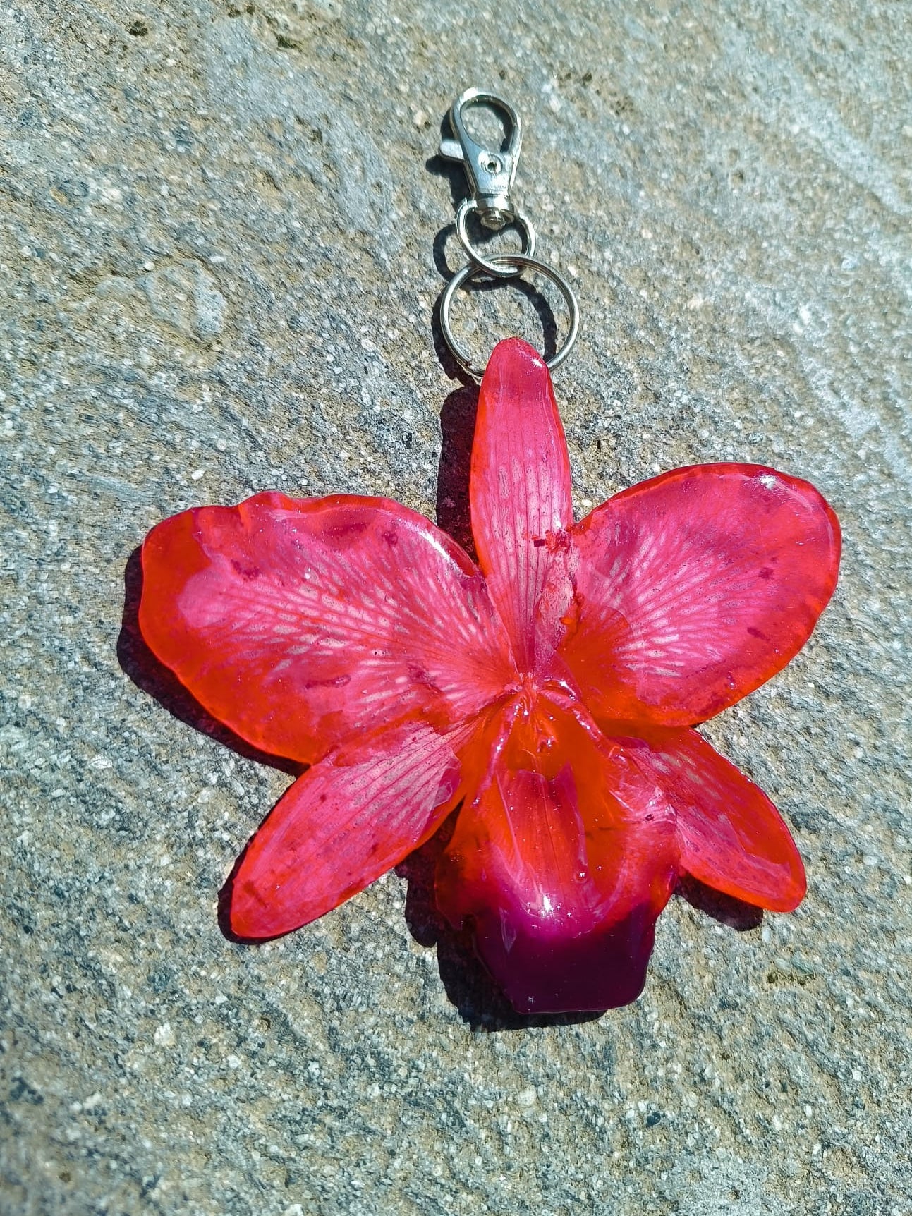 Ciondolo orchidea rossa vera in resina trasparente, pendente floreale artigianale per borsa o collana