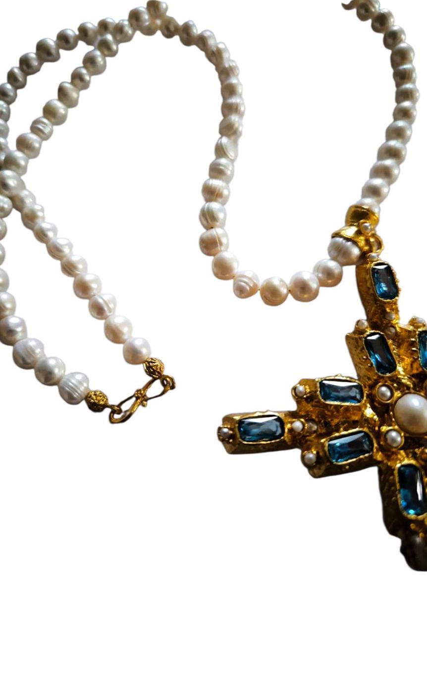 Collana artigianale stile bizantino con grande croce in oro su bronzo decorata con quarziti verdi e perle bianche, design elegante e scenografico.