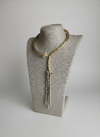 Collana etrusca regolabile in oro su bronzo con testa di ariete scolpita e fili di perle oro e topazio blu, design artigianale elegante e simbolico.