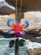 Collana con orchidea naturale azzurra e rossa inglobata in resina e saliscendi oro su bronzo regolabile