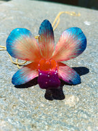Collana con orchidea naturale azzurra e rossa inglobata in resina e saliscendi oro su bronzo regolabile