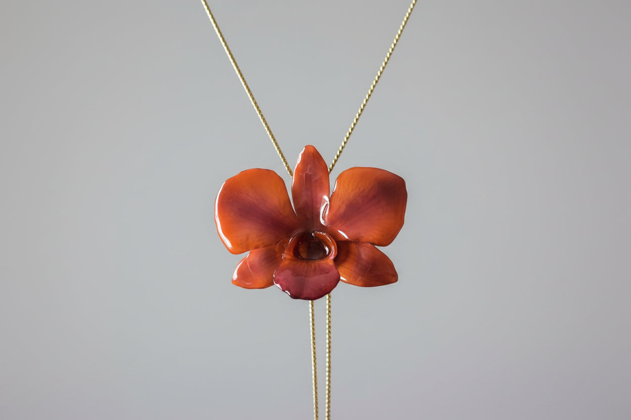 collana orchidea arancio resina effetto luminoso elegante gioiello solare per donna